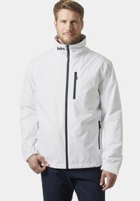 Chaqueta impermeable blanca con un alto collar, cremallera frontal y detalles en azul marino. Incluye bolsillos con cremallera y detalles de herrajes en contraste.