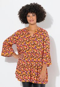 Buntes, locker sitzendes Tunika mit V-Ausschnitt. Verfügt über einen abstrakten Druck in Schwarz, Orange, Pink und Lila. Fließende Glockenärmel und gestuftes Design.