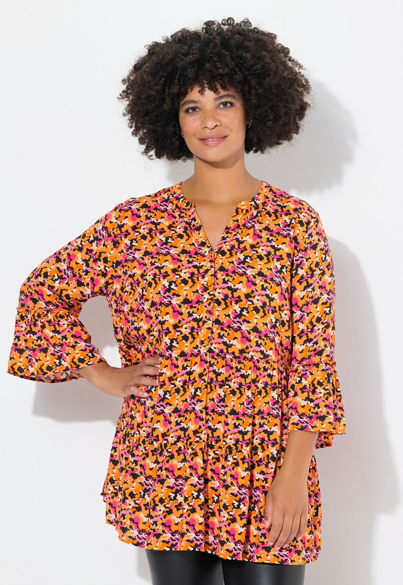 Buntes, locker sitzendes Tunika mit V-Ausschnitt. Verfügt über einen abstrakten Druck in Schwarz, Orange, Pink und Lila. Fließende Glockenärmel und gestuftes Design.