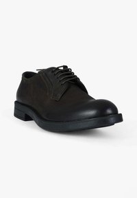 Scarpa da uomo elegante in pelle nera con punta arrotondata, lacci sottili e tomaia texturizzata. Caratterizzata da suola in gomma solida e dettagli di cuciture sottili.
