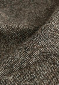 Woven fabric in shades of brown and gray, featuring a textured pattern with visible fibers and a soft, warm appearance.