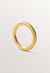 Anillo de oro con un acabado texturizado y mate. Forma circular con una superficie interior lisa. Diseño simple, sin adornos visibles.