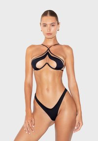 Black bikini set featuring string details, cut-out accents, and a minimalist design. Fabric appears smooth with a fitted shape.