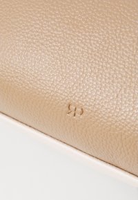 Pungă din piele texturată bej cu un logo „RP” embosat vizibil. Finisaj neted cu un grain subtil pe întreaga suprafață.