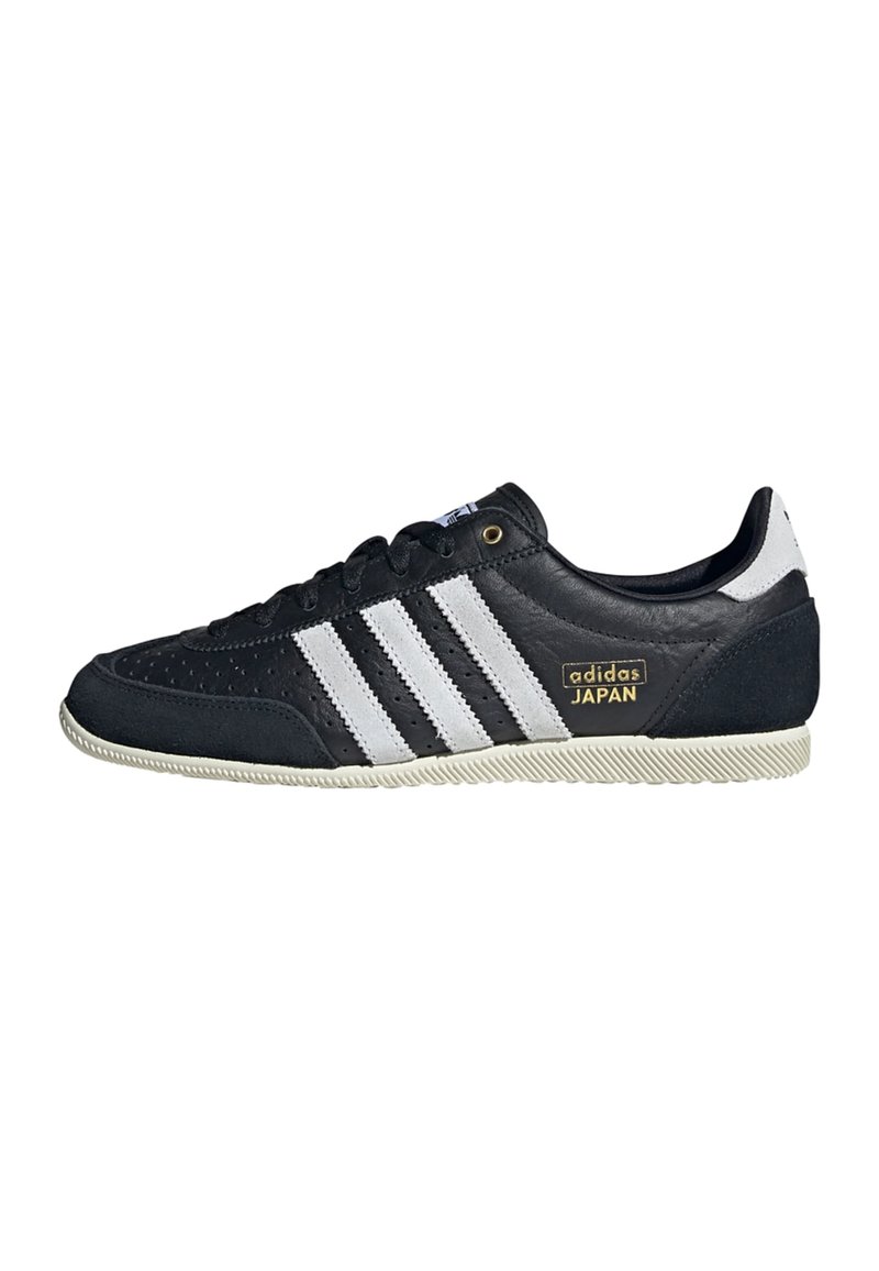 Black leather sneakers featuring three white stripes, a textured finish, gold "adidas JAPAN" logo, and a rubber sole with grip pattern.