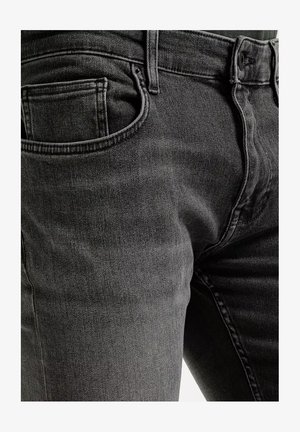 Zbliżenie na ciemnoszare dżinsy pokazujące przednią kieszeń, pętlę na pasek, guzik i zamek błyskawiczny.