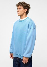Lichtblauwe sweatshirt van een zachte katoenmix, met een klassieke ronde hals, geribde boorden en een klein logo op de linkerkant van de borst.