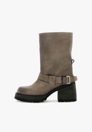 Botín de ante gris con detalle de hebilla, tacón grueso texturizado y suela de plataforma alta, con un acabado suave y punta redonda.