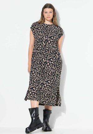 Luipaardprint jurk in bruin en zwart polyester, knielang met kapmouwen, met een ontspannen pasvorm en zijsplitten. Draagt met zwarte enkellaarsjes.