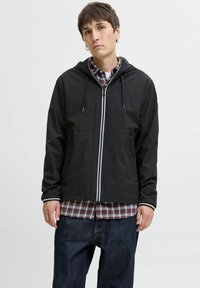 Veste noire à capuche avec zip à l'avant, dotée de passepoils blancs, de deux poches à l'avant et portée sur une chemise à carreaux. Texture de tissu lisse et soyeuse.