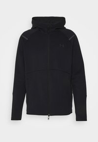 Felpa nera con zip e colletto alto, dotata di cappuccio, in tessuto morbido, con cuciture piatte e dettagli grigi sulle spalle. Logo Under Armour visibile.