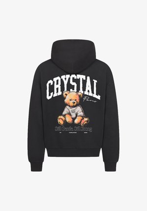 Felpa nera con cappuccio che presenta una grafica di un orsetto con una maglietta con il testo "Crystal Paris" e lo slogan "Ancora Gentile. Ancora Forte".