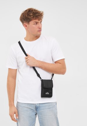 Borsa a tracolla nera realizzata in tessuto testurizzato, con chiusura a pattina e tracolla regolabile. Logo stampato sul davanti.