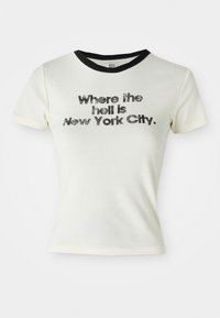 Vit bomull t-shirt med svart rund halsringning. Grafisk text meddelar: "Var i helvete ligger New York City" i fet, sliten stil.