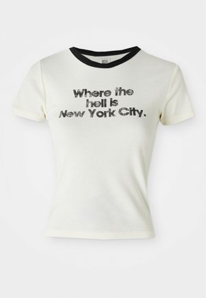 T-shirt en coton blanc avec col rond noir. Le texte graphique indique : "Où diable est New York City", en lettres grasses et usées.