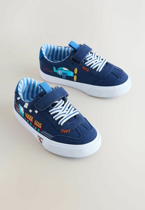Blaue Stoff-Sneaker mit weißen Gummisohlen, mit bunten, bestickten Motiven eines Flugzeugs und eines Zuges. Gestreiftes blaues Innenfutter.