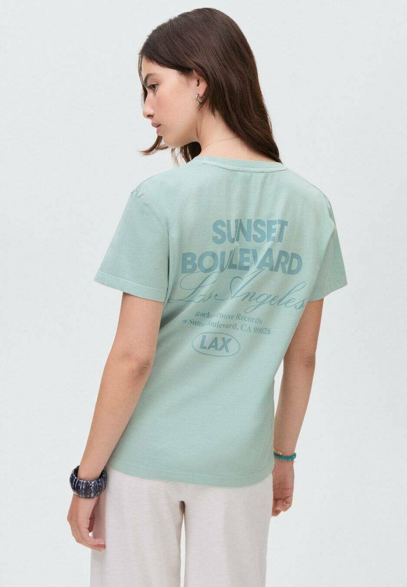 Minttivihreä lyhythihainen t-paita, jossa on graafinen kuviointi "SUNSET BOULEVARD" ja "Los Angeles" -teksti selässä. Pehmeää materiaalia.