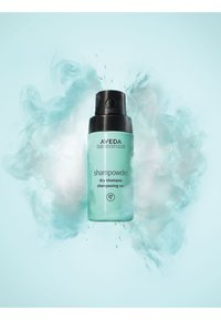 Aveda Shampowder droogshampoo in een doorzichtig mintgroen flesje met een zwarte pompdeksel. Minimalistische etikettering met een logo en productnaam.