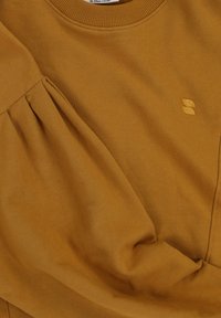 Mosterdgele sweatshirt met een ronde halslijn, geplooide details aan de zijkant en geborduurd logo, gemaakt van zachte stof.