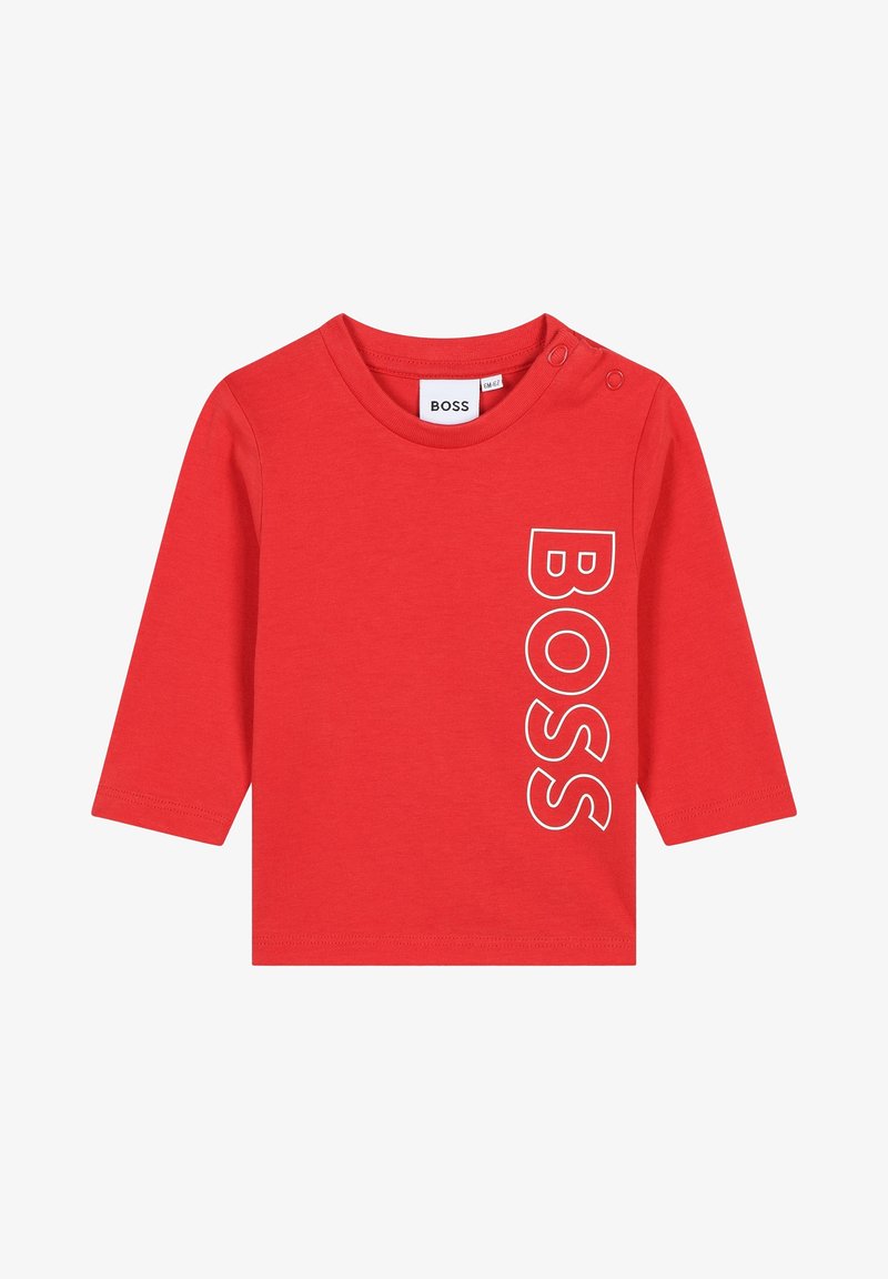 T-shirt rouge à manches longues en coton avec un col rond, arborant un logo "BOSS" blanc imprimé verticalement sur le côté gauche. Boutons-pression à l'épaule.
