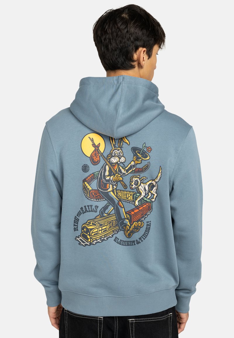 Felpa blu con grafica sul retro che raffigura un coniglio con una borsa e un cane, circondati da treni e da una luna gialla. Tessuto morbido in mistura di cotone, vestibilità ampia.