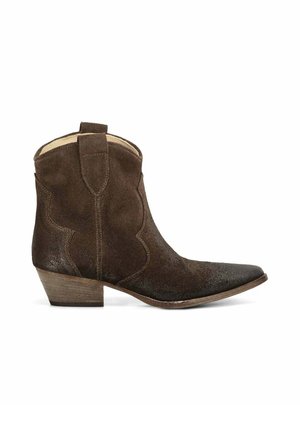 Bottine western en daim marron foncé à bout pointu, talon en bois empilé bas, et languettes au col, visible de profil sur fond blanc.