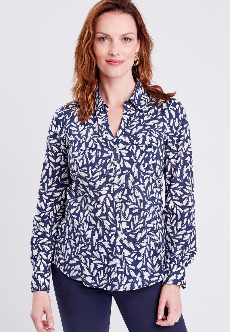 Camicia button-up blu navy con motivo a foglie bianche, maniche lunghe, colletto e due tasche sul petto. Tessuto leggero con una consistenza liscia.