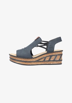 Schwarze Keiluhren mit Kreuzriemen-Design, Korkplattform und strukturiertem Gummisohle. Verfügt über ein auffälliges Marken-Highlight an der Seite.