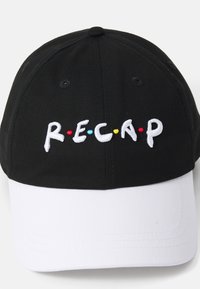 Baseballcap med en sort bomuldskrone og en hvid skygge. Har broderet "R.E.C.A.P" i hvid med røde, gule og blå prikker mellem bogstaverne.