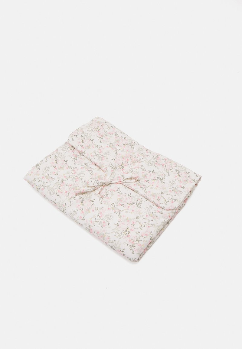 Sulankstytas gėlių antklodė su baltu fonu, papuošta rožinėmis ir žaliomis gėlėmis, surišta atitinkamu audinio kaspinu. Minkštas, lygus paviršius.