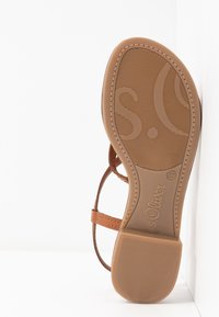 Semelle de sandale avec grip texturé, couleur fauve, nom de marque "s.Oliver", taille 37, et fines fines lanières brunes visibles sur le côté.