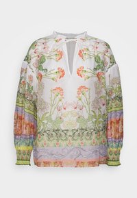Blouse blanche à fleurs avec manches bouffantes, ornée d'imprimés botaniques verts et orange. Accent notable sur les plis et un décolleté en V profond.