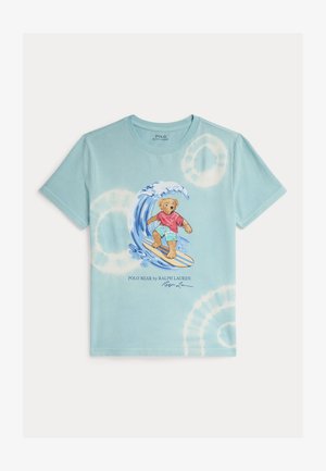 Svijetloplava majica s tie-dye uzorkom na kojoj je medvjed koji surfa na valovima, nosi crvenu majicu i aqua kratke hlače, s natpisom "Polo Bear by Ralph Lauren" ispod.