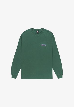 T-shirt à col rond à manches longues de couleur vert foncé avec un petit logo ovale et le texte "A un goût de paradis" sur le côté supérieur gauche de la poitrine.