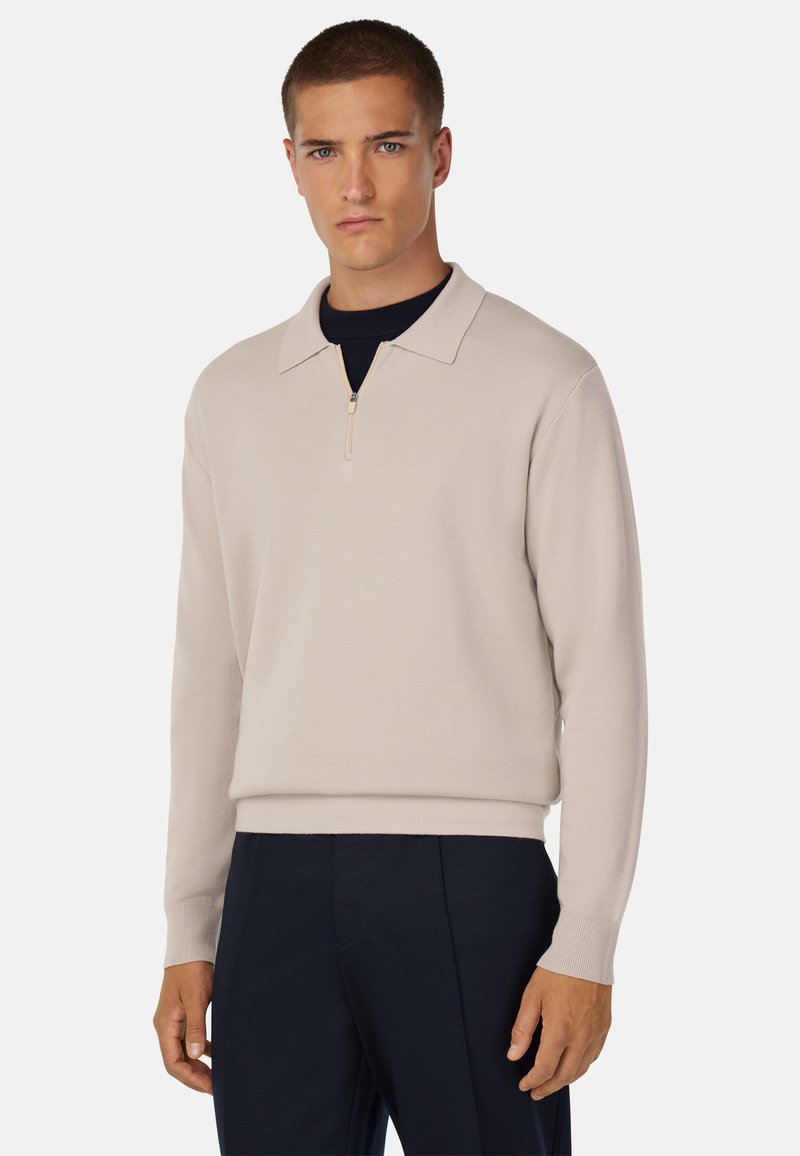 Svetložltý zipsový sveter s prehnutým golierom a rebrovanými manžetami, vyrobený z textúrovanej pleteniny. V kombinácii s námorníckymi nohavicami.