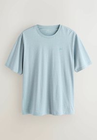 T-shirt bleu clair à manches courtes avec col rond, texture subtile et petit logo brodé sur le côté gauche de la poitrine sur un fond uni.