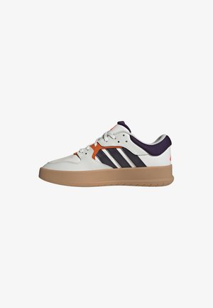 White sneaker with gray midsole, orange and navy accents, three dark lateral stripes, and a textured gum rubber outsole.