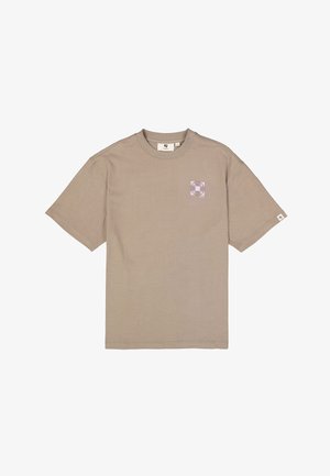 Camiseta de algodón beige, cuello redondo, mangas cortas, con un pequeño gráfico geométrico morado en el pecho y una etiqueta en la manga izquierda.