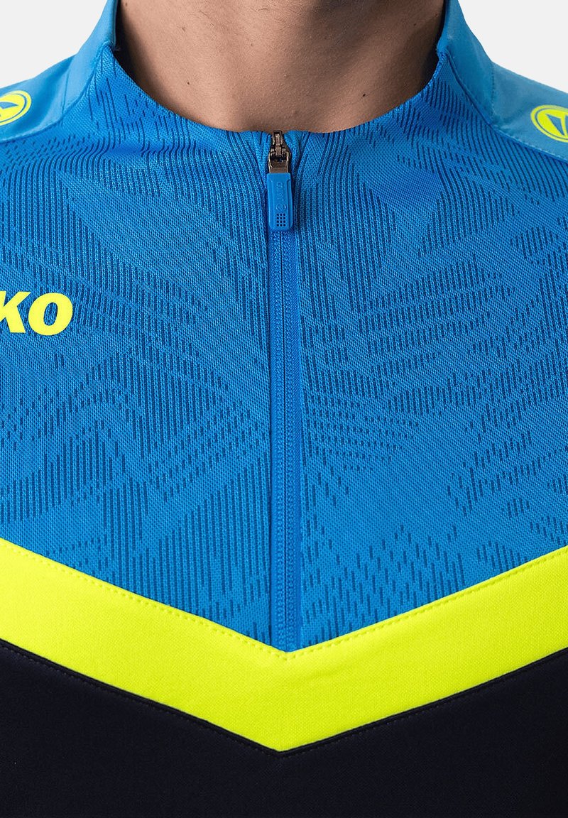 Maglia da ciclismo blu con un motivo testurizzato, dettagli gialli, zip di un quarto di lunghezza e una sezione inferiore nera. Logo visibile sulla spalla.
