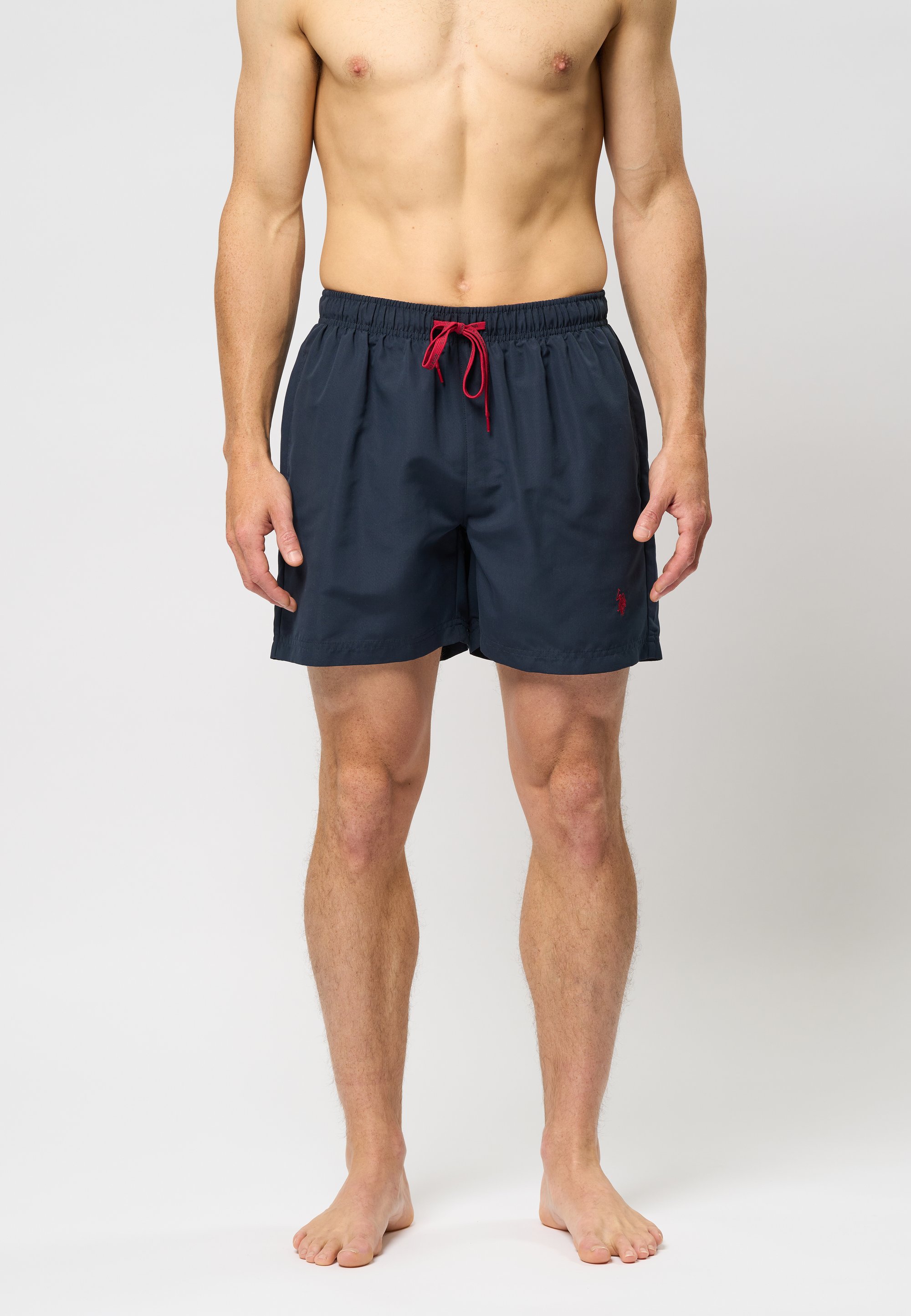 Navy swim shorts made of lightweight fabric, featuring a red drawstring, side pockets, and a small logo on the hem.