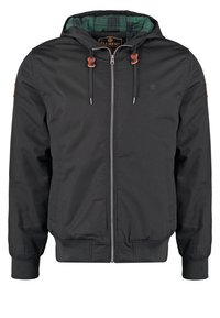 Czarna kurtka z kapturem, zapinana na przedni zamek błyskawiczny, z elastycznymi mankietami i ściągaczem u dołu. Wnętrze wyściełane zieloną kratką. Zawiera brązowe skórzane akcenty na ramionach.
