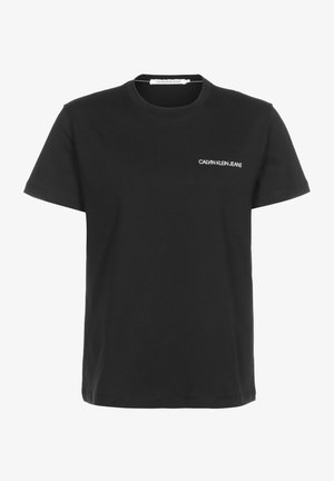 T-shirt en coton noir avec un col ras du cou classique. Affiche un logo blanc "CALVIN KLEIN JEANS" sur le côté gauche de la poitrine. Manches courtes ; coupe décontractée.