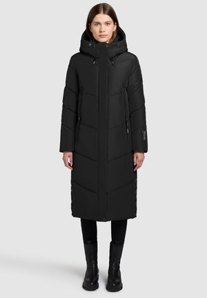Manteau en duvet noir avec capuche, présentant un design matelassé, des fermetures éclair et des boutons-pression sur les côtés. Silhouette longue et droite avec une texture lisse.