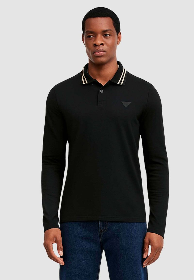 Czarna koszulka polo z długim rękawem i kołnierzykiem ozdobionym kremowymi paskami. Charakterystycznym elementem jest małe logo marki na piersi. Gładka struktura.