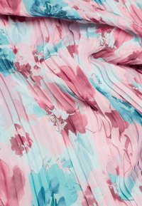 Faltenstoff mit einem floralen Muster in Pink-, Türkis- und zarten Weißtönen auf einem weichen, leichten Material.
