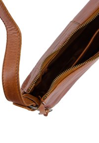 Brown leather crossbody bag with a zip closure, textured surface, and an adjustable strap, showcasing an inner pocket and smooth lining.