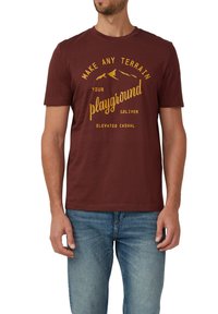 Bordowa bawełniana koszulka z krótkim rękawem, z żółtym motywem gór i napisem "Zamień każdy teren w swoje plac zabaw."