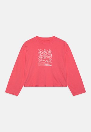 T-shirt court à manches longues couleur corail rose avec un motif abstrait de feuilles blanches et le texte « everything is culture RAIZED » sur le devant.