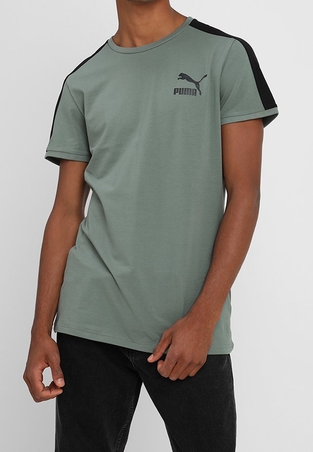 T-shirt verde a maniche corte in cotone, con dettagli neri sulle spalle e un piccolo logo Puma nero sul petto.