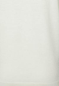 Světlý slonovinový pletený textil, hladký povrch, s jemným finišem bez viditelných vzorů nebo kovových prvků. Vhodný pro volnočasové nošení.